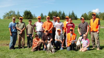 Group of people and dogs outdoors wearing orange