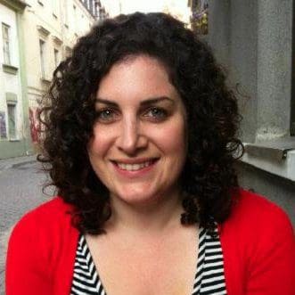 A woman with curly hair smiling for the camera