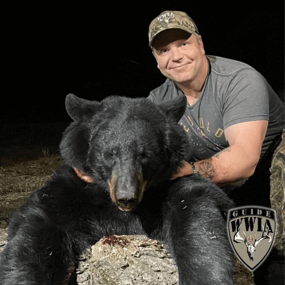 Man posing with large black bear
