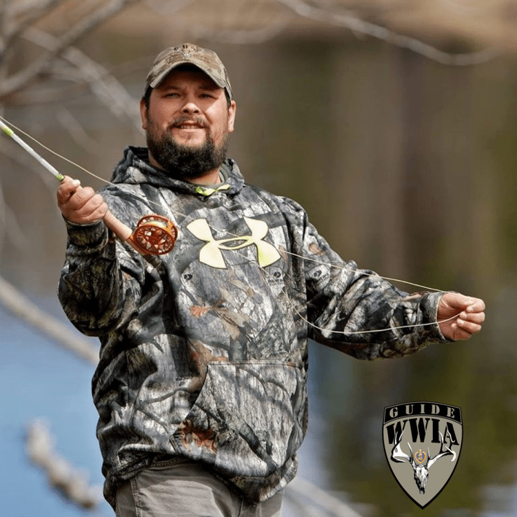 A man in camouflage holding a fishing rod.