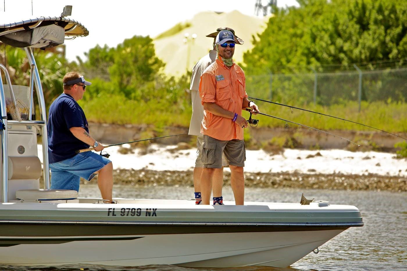 Two men on a boat fishing in the water