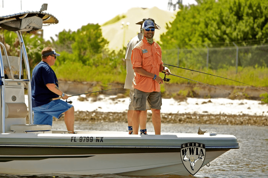 Two men on a boat fishing in the water.