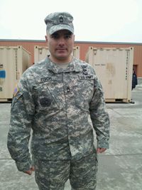 A soldier in uniform standing in front of a building.