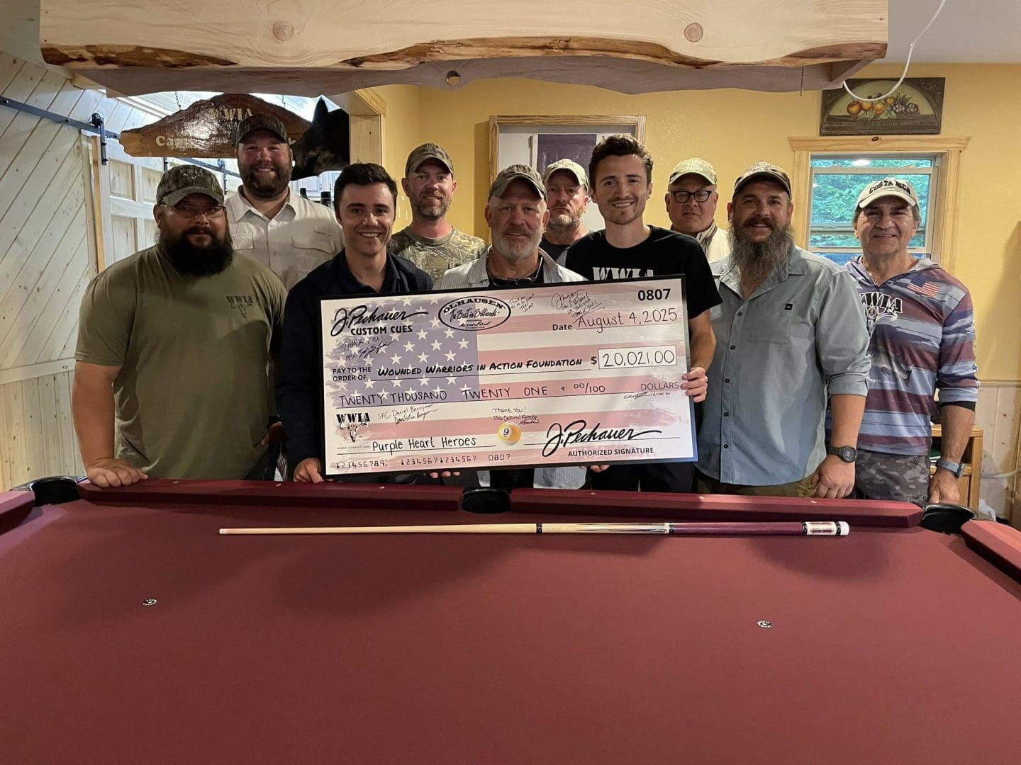 Group of men holding a large check