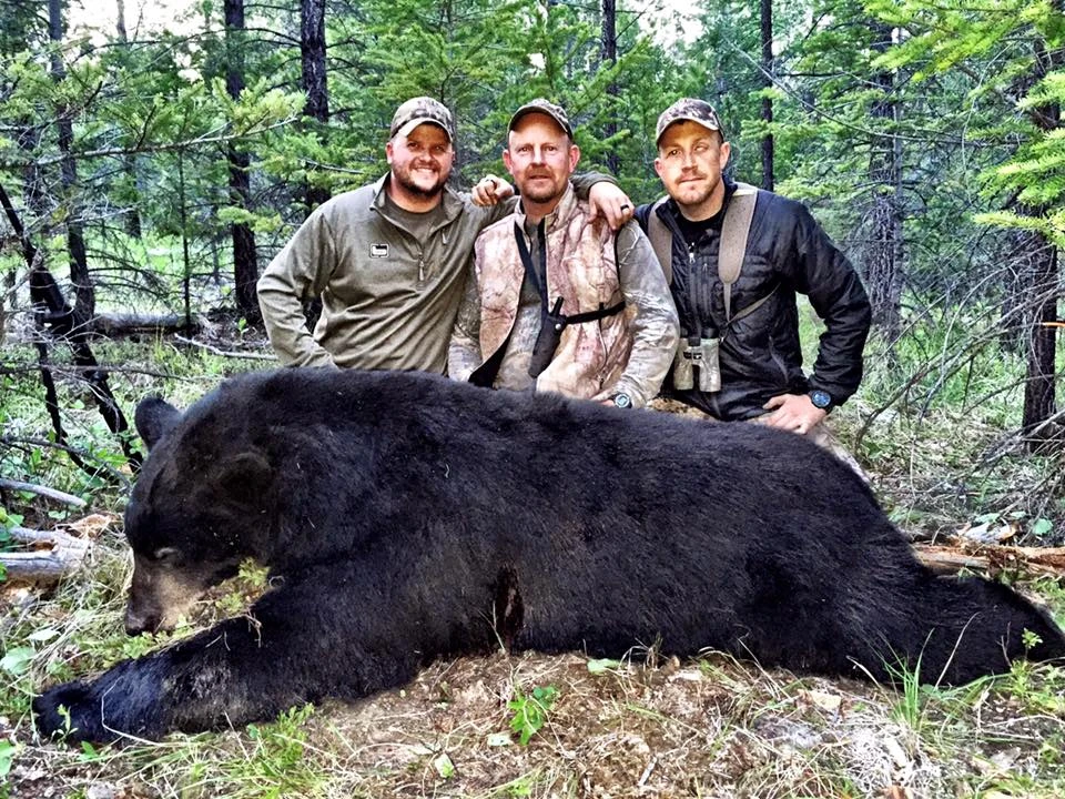 Hunters with trophy black bear in forest Wounded Warriors in Action Foundation Hunters with trophy black bear in forest