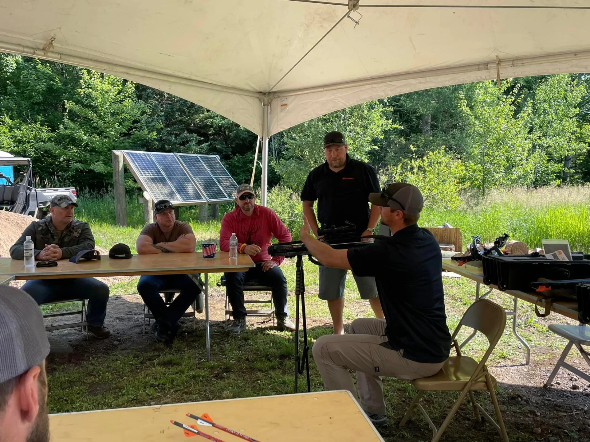Outdoor meeting under tent people seated listening