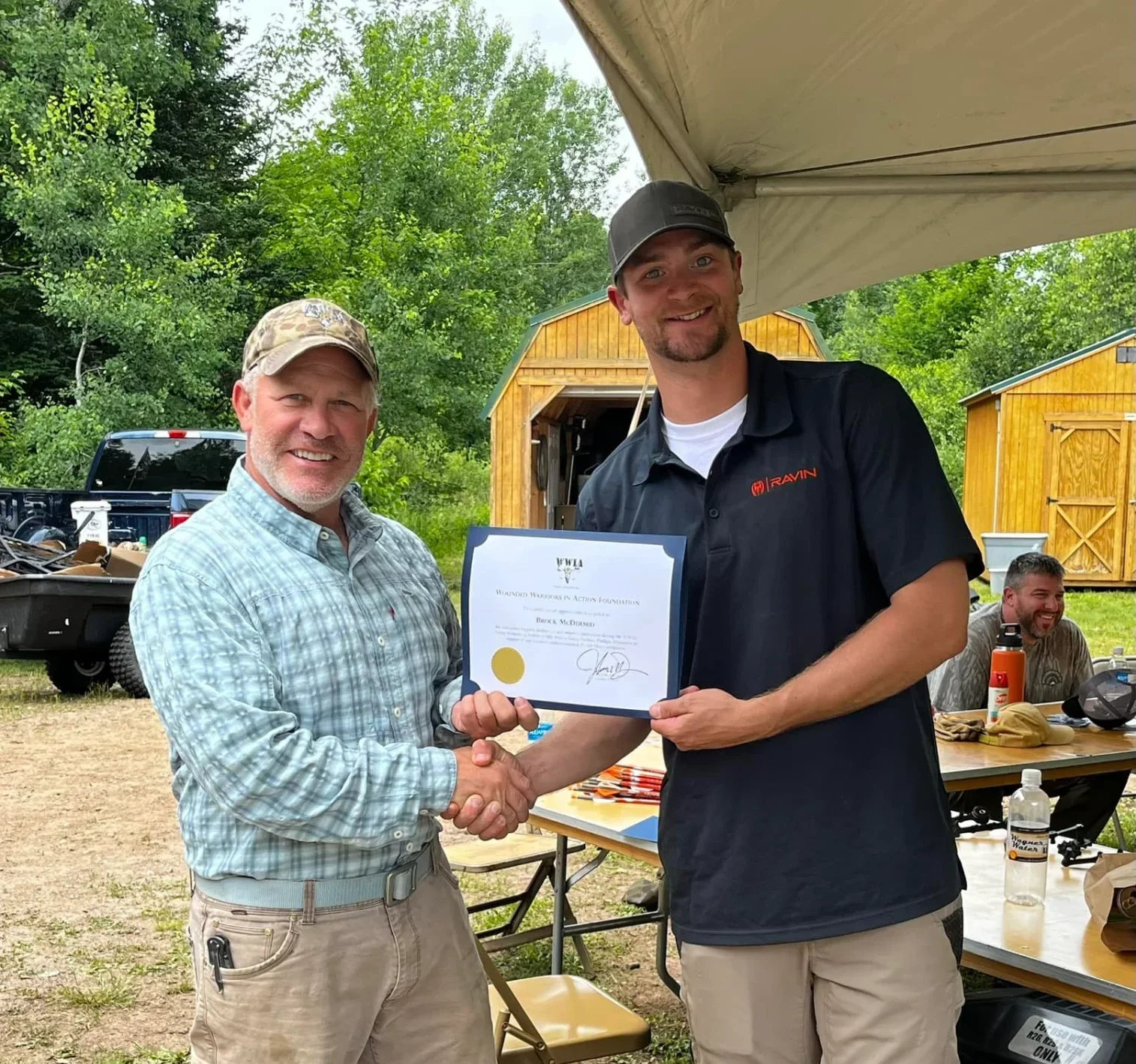Two men shaking hands with a certificate