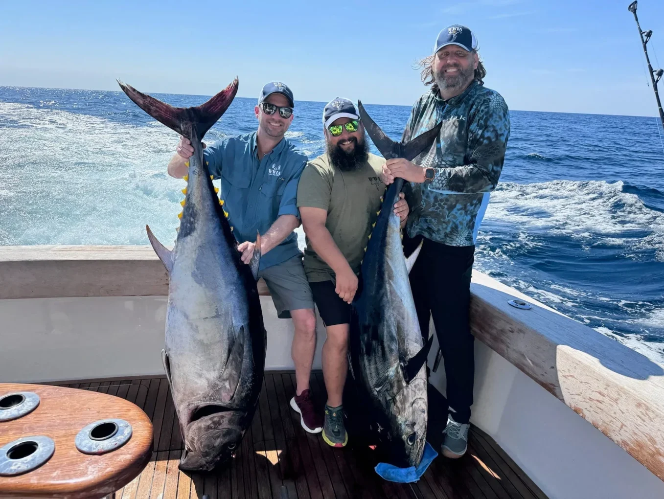 Three men proudly holding large fish onboard Wounded Warriors in Action Foundation Three men proudly holding large fish onboard