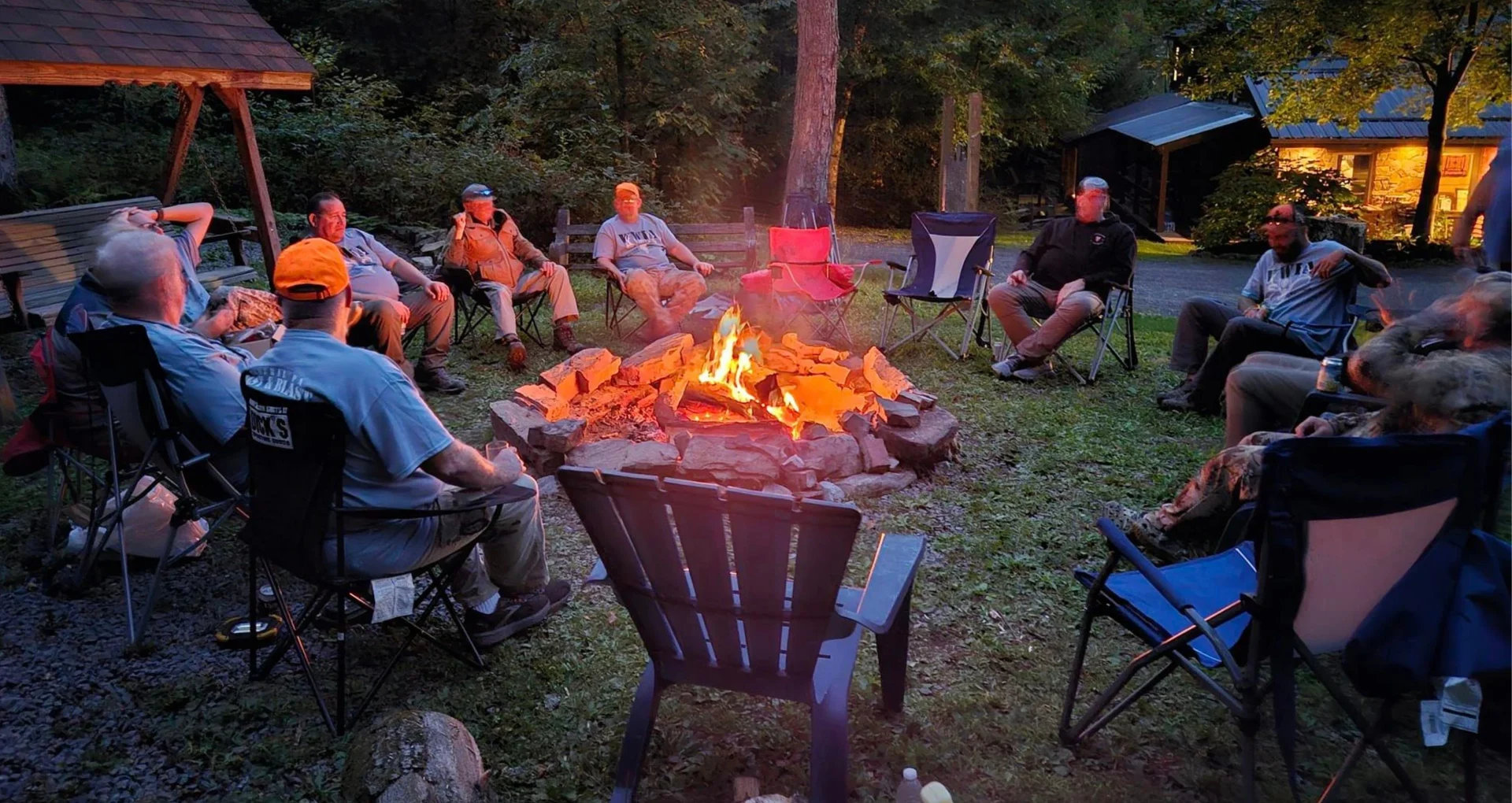 Group sitting around a campfire outdoors Wounded Warriors in Action Foundation Group sitting around a campfire outdoors