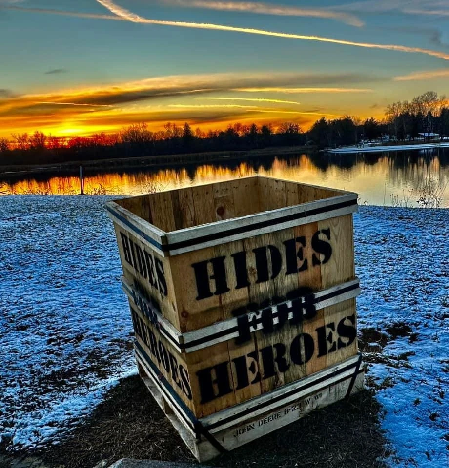 Wooden crate by lake at sunset.