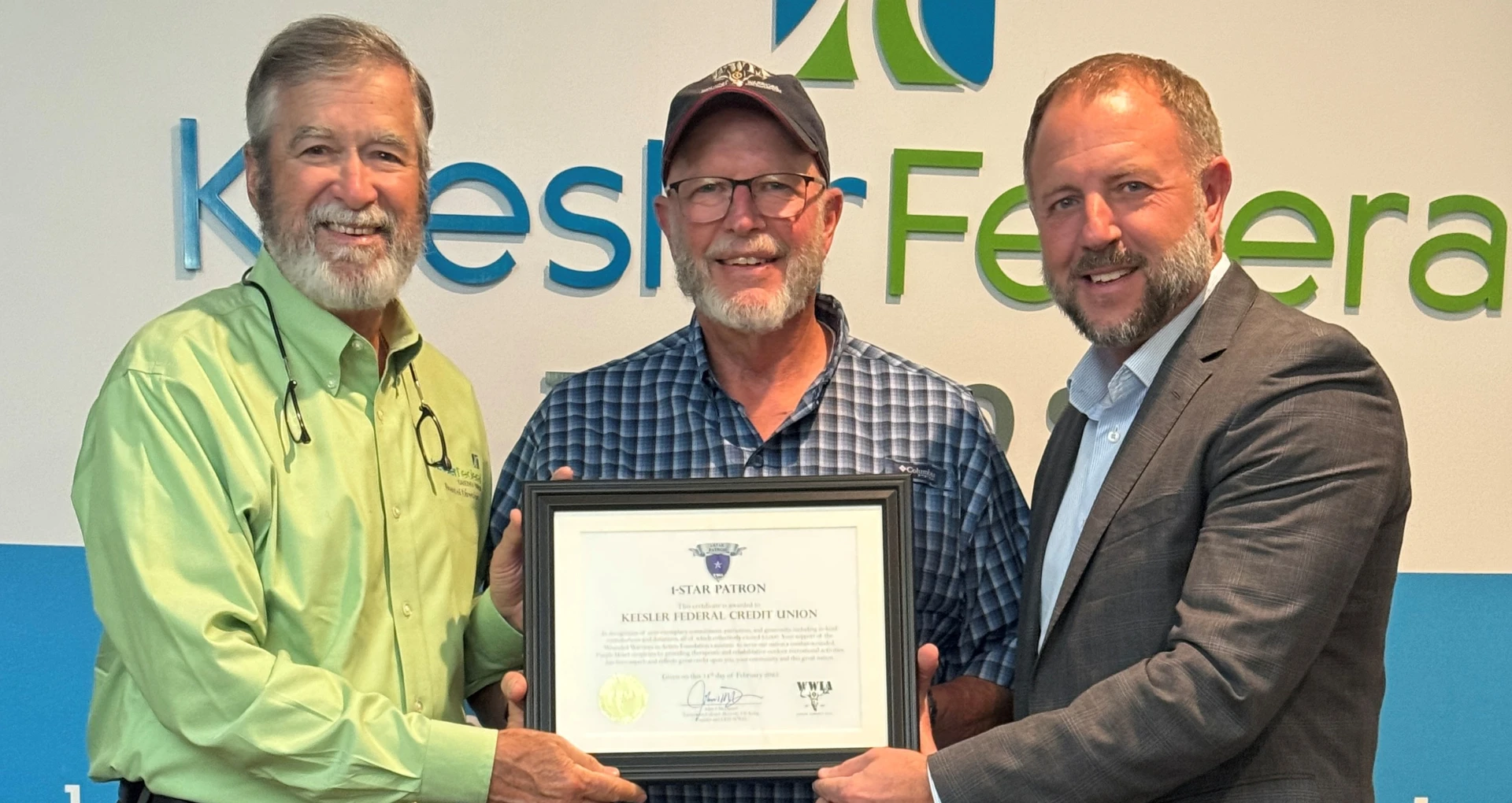 Three men holding an award certificate