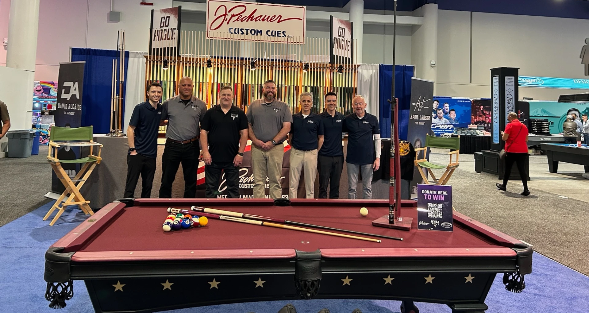 Group posing behind pool table at event