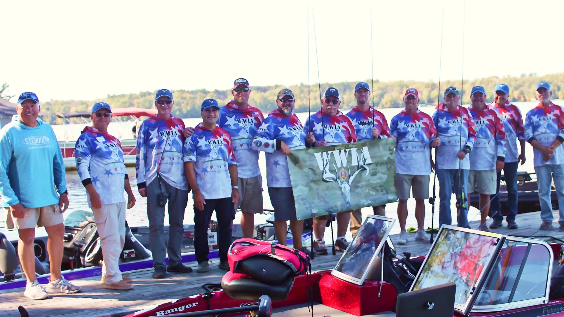 Anglers in patriotic jerseys holding banner on dock