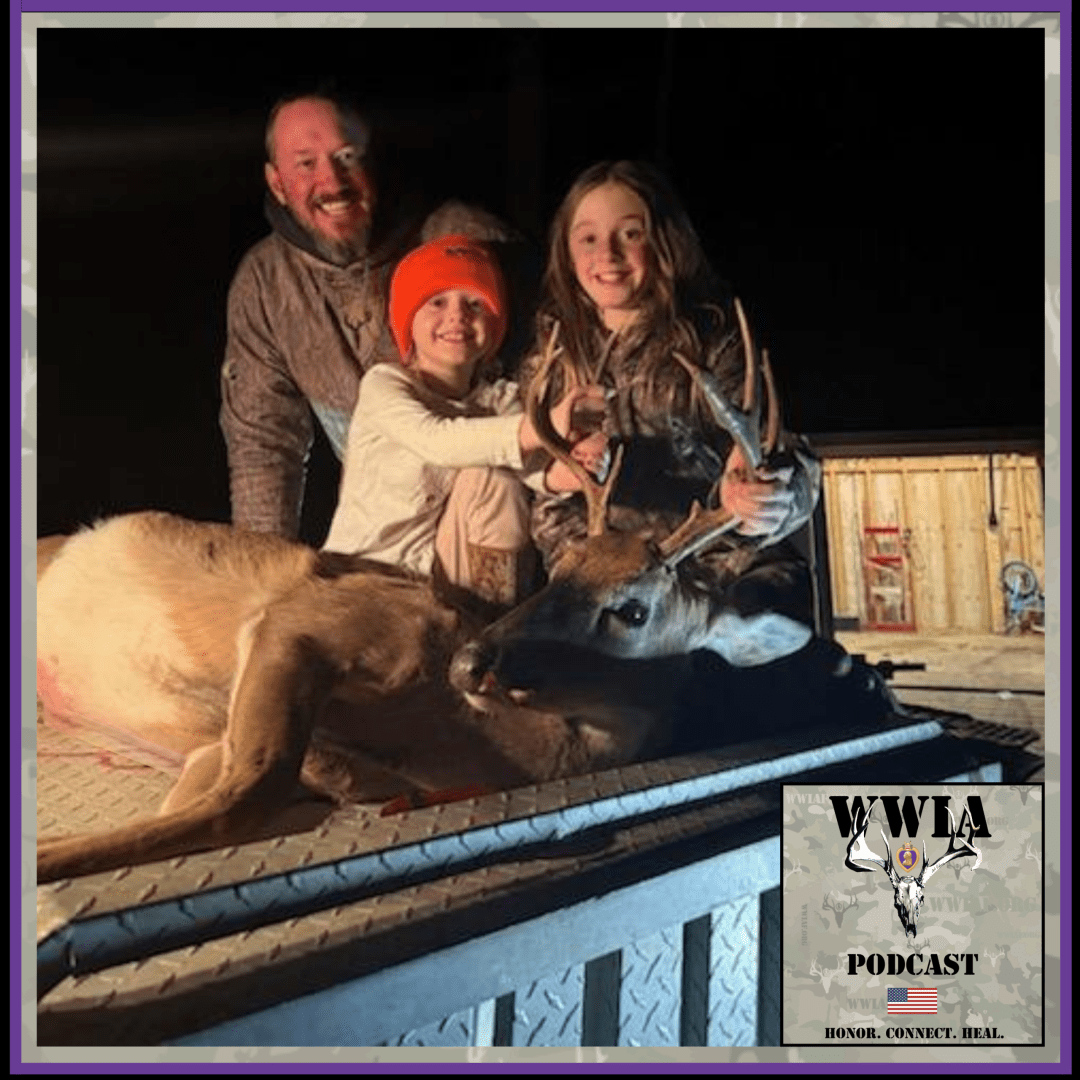 Family posing with deer on truck bed